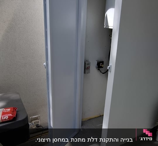 דלת מתכת פתוחה ליד קיר חיצוני